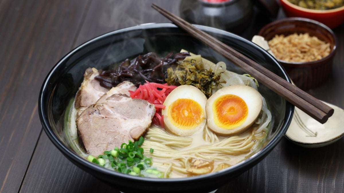 A bowl of ramen with a slice of pork and eggs